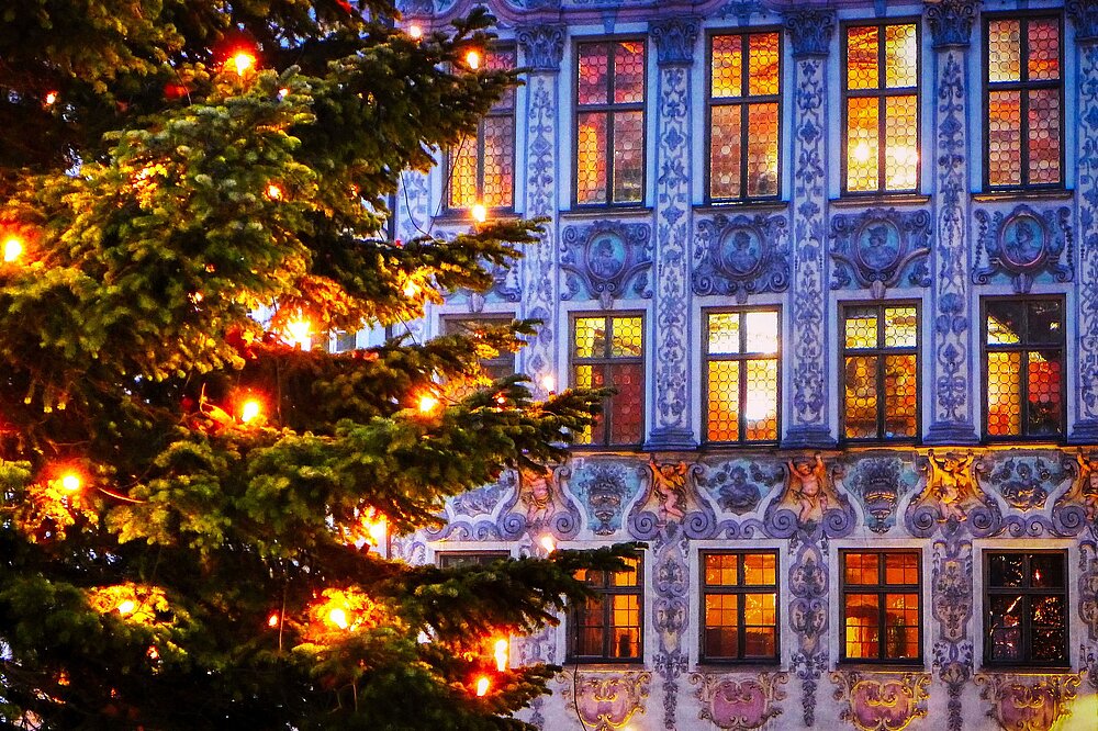 Weihnachtlich illuminierte Fachwerkfassade mit blauen Lichterketten und bemaltem Giebel in Landsberg am Lech – festliche Atmosphäre am Christkindlmarkt.